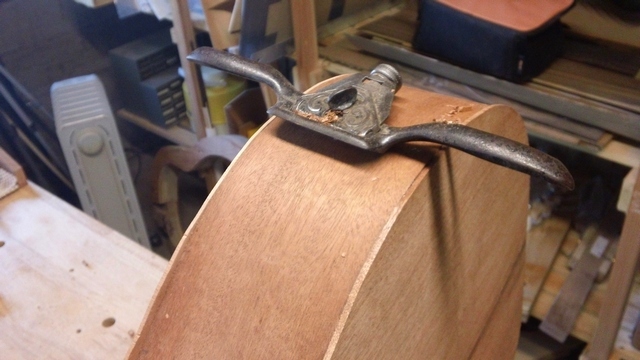 Just takes one hand to use the spokeshave, I hold the guitar to the bench with the other hand.