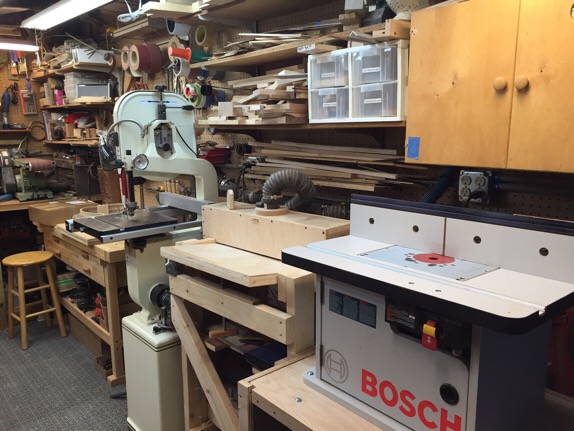 Flip table with table saw/router table, drum sander and band saw. Flip table and drum sander are on casters.