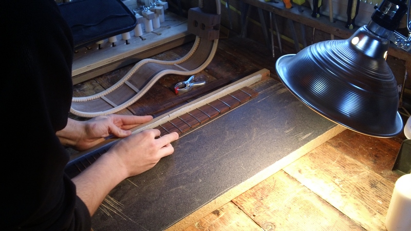 Flushing up the fret ends. I showed a little mercy, after he had suffered a bit, and let him use the belt sander to clean it up. I'm mean.